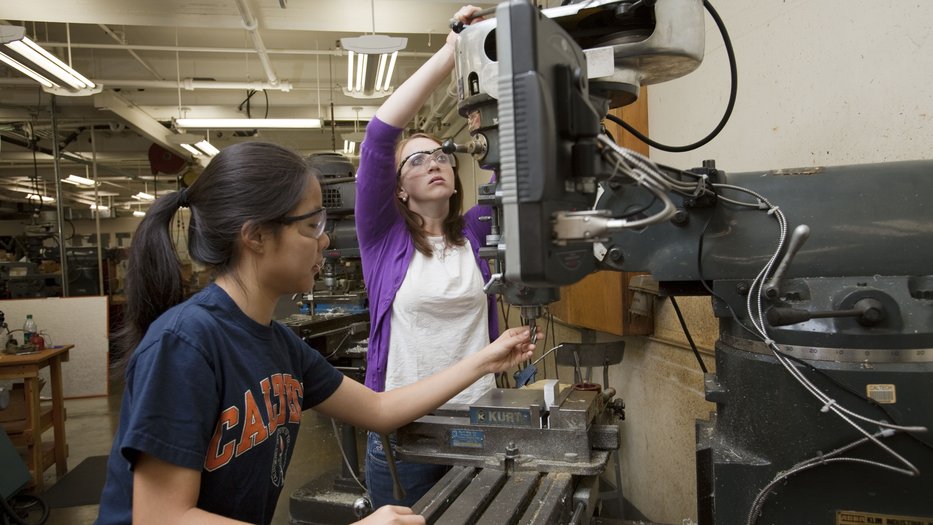 Two students working on a machine in a lab