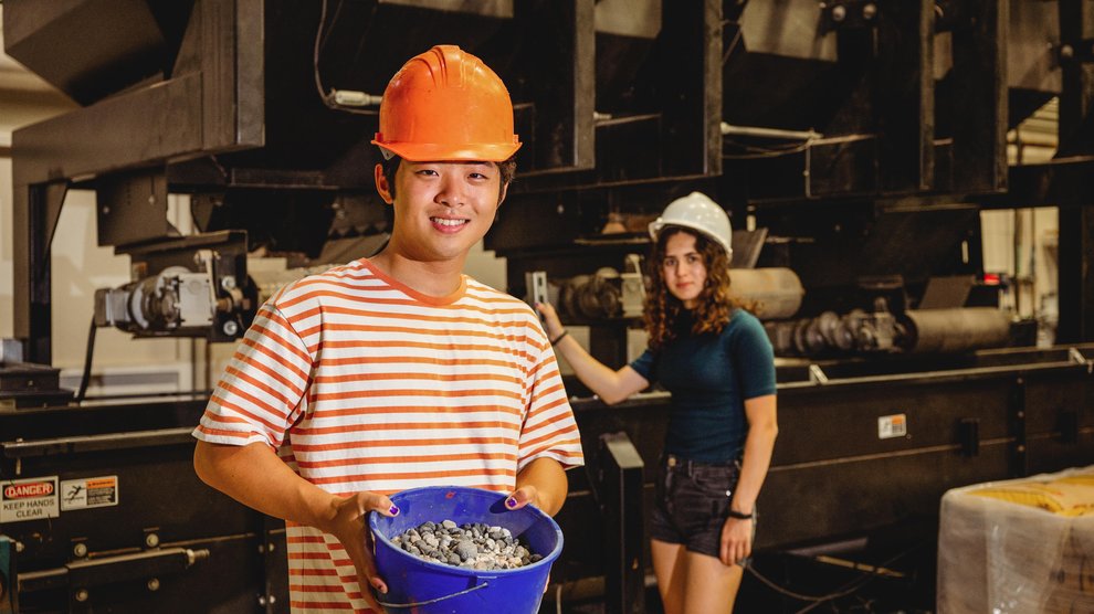 students examining rocks in a bucket