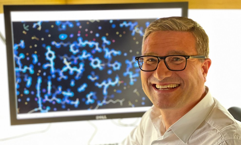 Photo of Caltech professor Andre Hoelz in front of a computer monitor