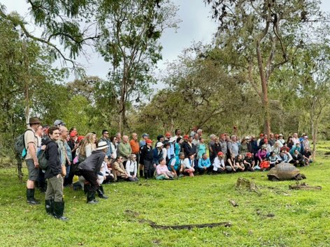 A group of travelers with a giant tortoise
