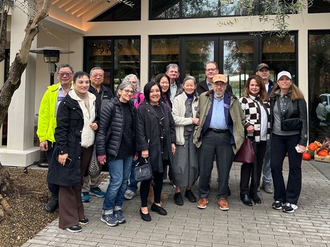 A group of travelers posed outside a hotel