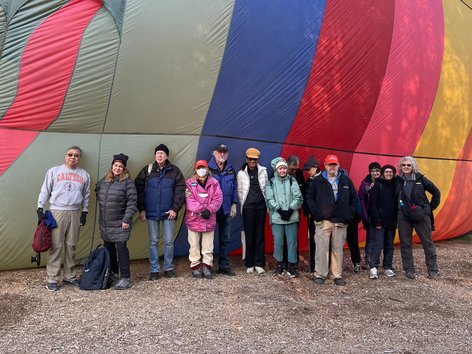 People standing in front of a hot-air balloon