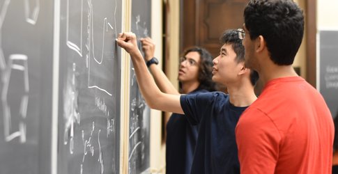 Student writing on chalkboard