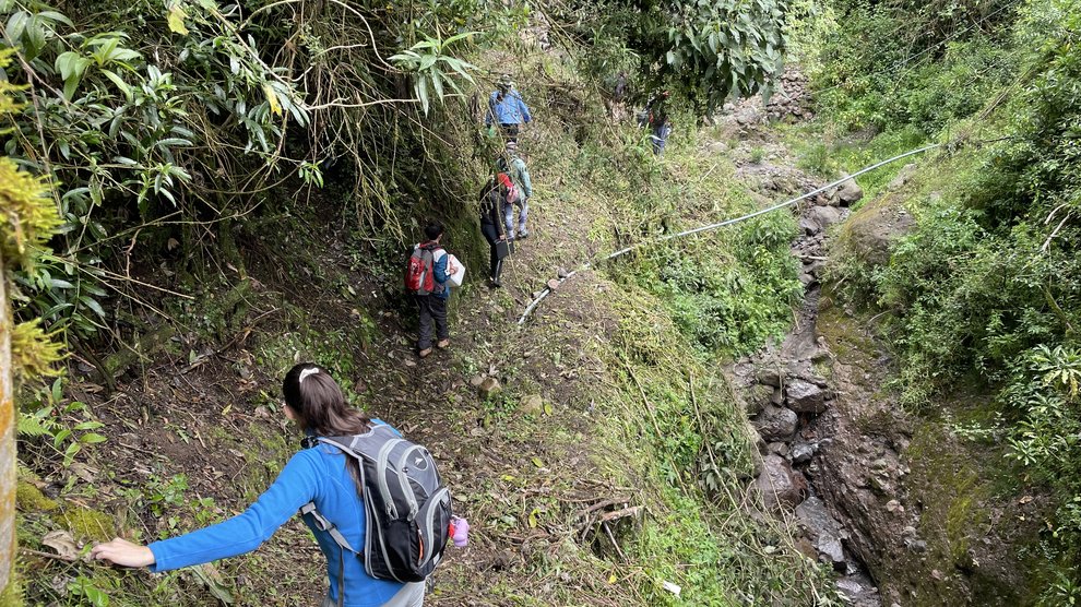 Members of the project team hike alongside a ravine