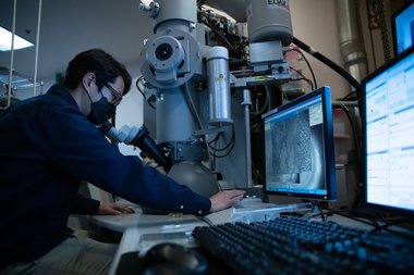 Changsoon Choi looking through electron microscope