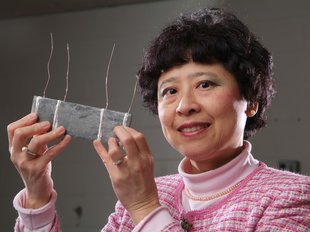 Dr. Deborah Chung holding a model of smart concrete.