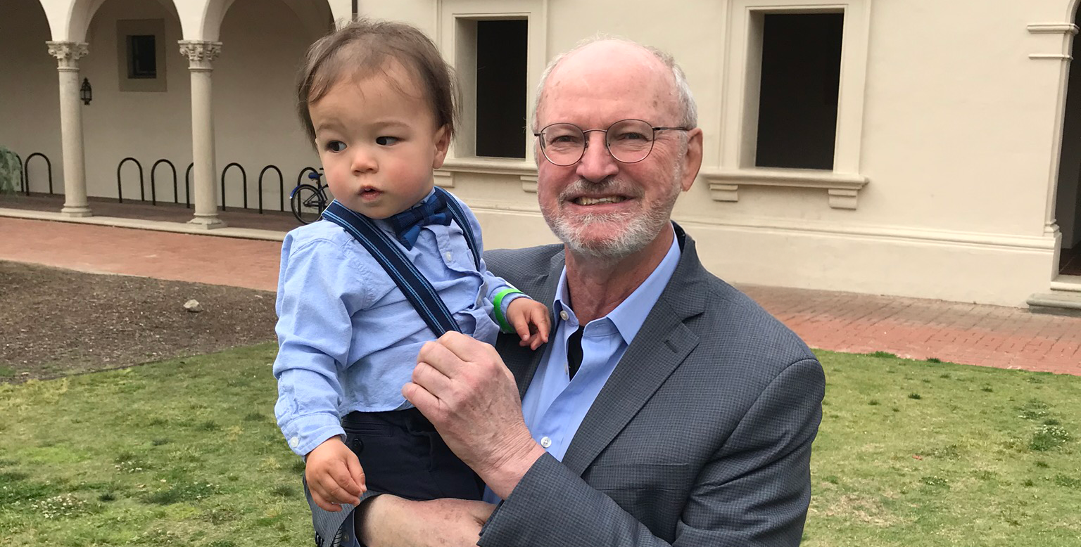 Robert Grubbs on campus holding his grandson
