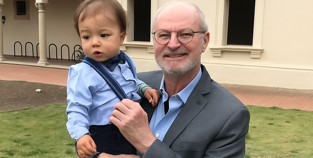 Robert Grubbs on campus holding his grandson