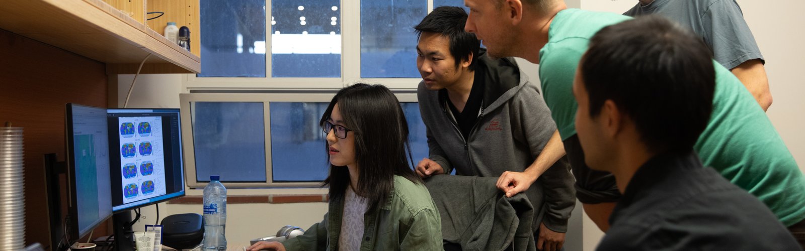 Five people gathered around a computer