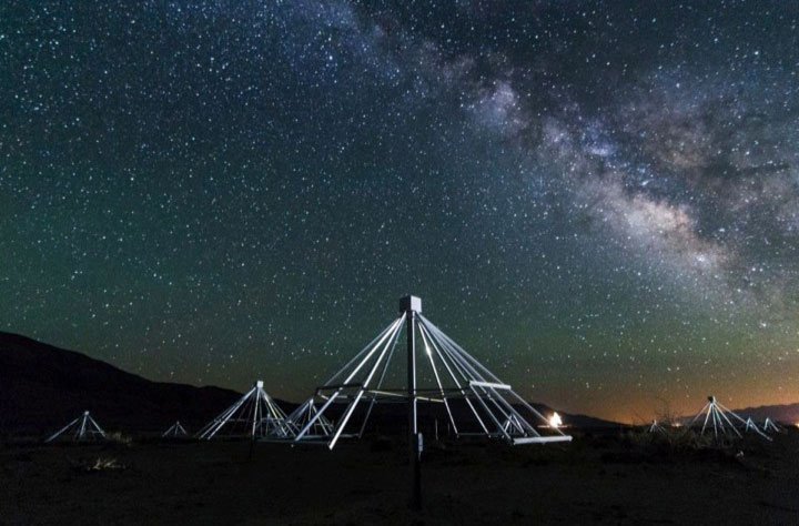 Night-time shot of Owens Valley Long Wavelength Array antennas with the center of our galaxy in the background