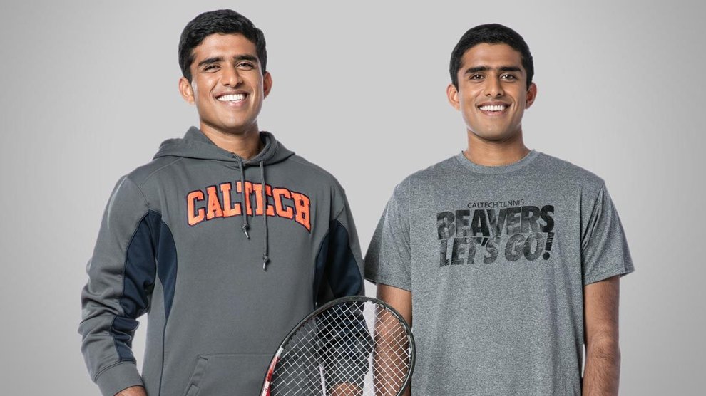 Brothers Ruthwick and Sathwick Pathireddy stand smiling with a tennis racket.
