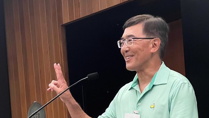 Alan Marumoto smiling at at podium