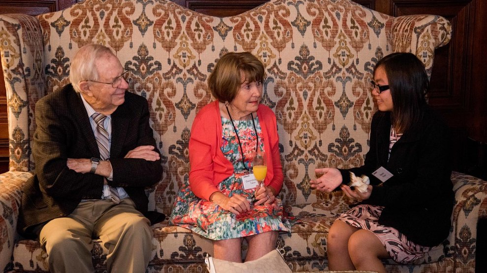 John (BS '46) and Gwendolyn Taber converse with Karen Pham (Class of 2020) on a couch.