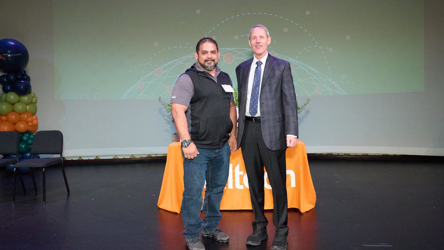 Two people on a stage. L to R Oswaldo Penaloza, Thomas F. Rosenbaum