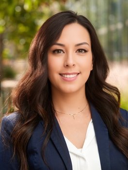 Person in a white shirt and blue blazer on a green background