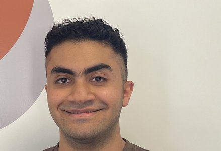 Young man in front of a logo