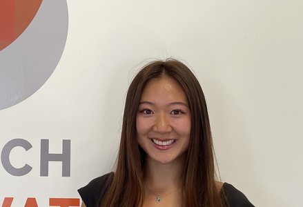 Young woman in front of a logo
