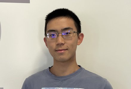 Young man in front of logo