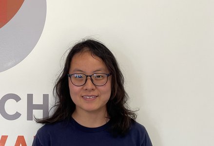 Young woman in front of a logo