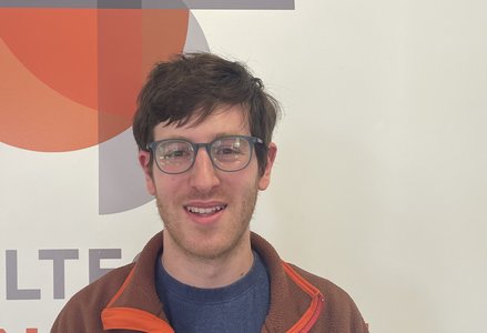 Young man in front of a logo