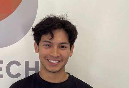 Young man in front of a logo