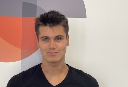 Young man in front of a logo