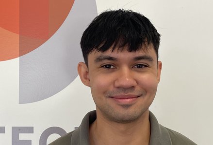 Young man in front of a logo