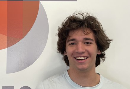 Young man in front of a logo