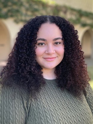 Photo of a young woman with curly hair smiling