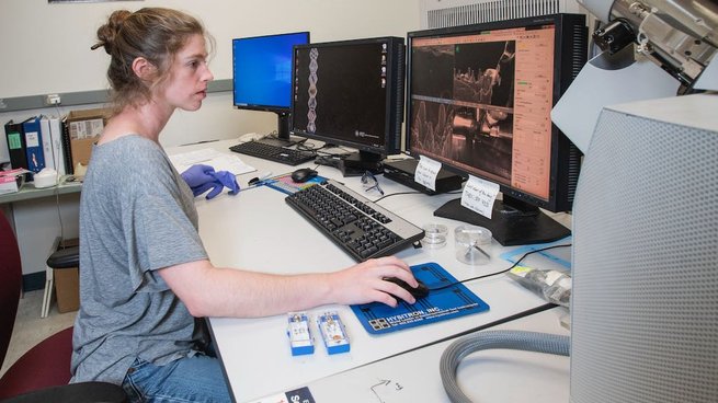 Rebecca Gallivan operating a scanning electron microscope.