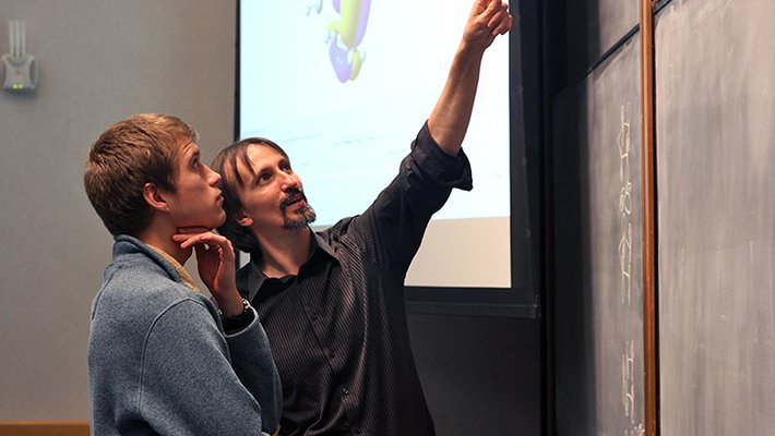 Teachers points to chalkboard