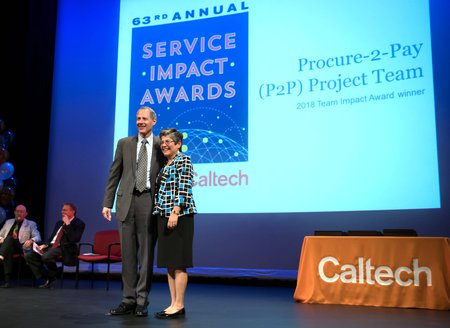 Tina Lowenthal (right), director of procurement for Purchasing Services, accepts the 2018 Team Impact Award on behalf of the P2P team.