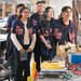 In a laboratory, five people in Garfield High School jackets look to the right of the camera.