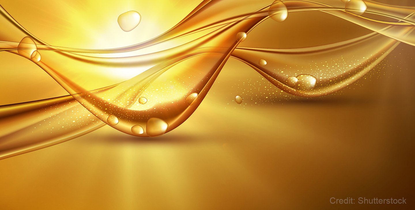 An abstract conceptual image featuring a wavy liquid with some drops and sunlight in the background.