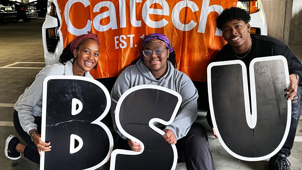 Ramona Murugu, Darleine Abellard, and Jayden Nyamiaka pose in front of the Caltech float after decorating it.