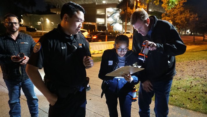 A group takes notes while surveying campus during the night walk.