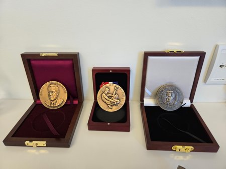 Three medals on display in their wooden boxes in John Dabiri's office.