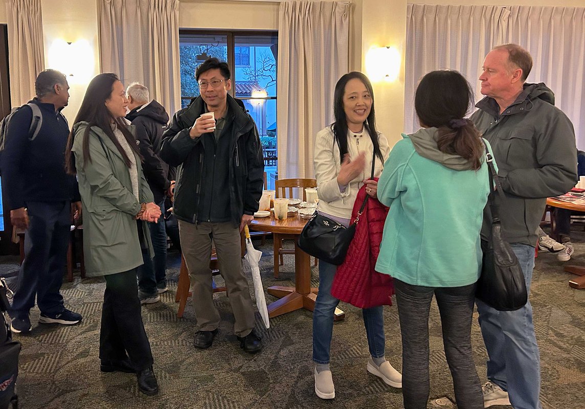 Two groups of adults standing and talking to one another