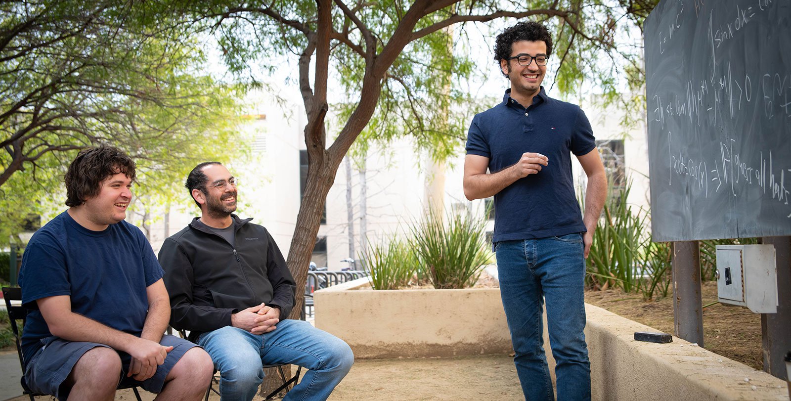 Joshua Frisch, Omer Tamuz, and Pooya Vahidi Ferdowsi discuss a math problem at Caltech.