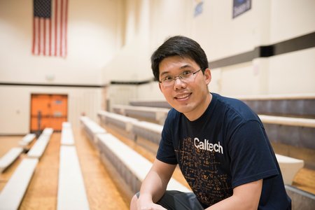 Image of Wei Gao seated in a basketball gymnasium