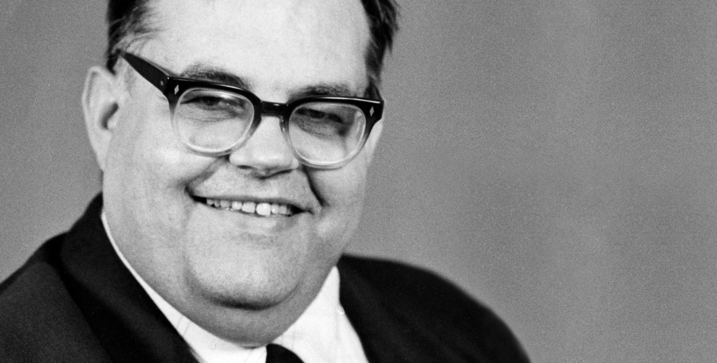A man in a suit smiles for a photo