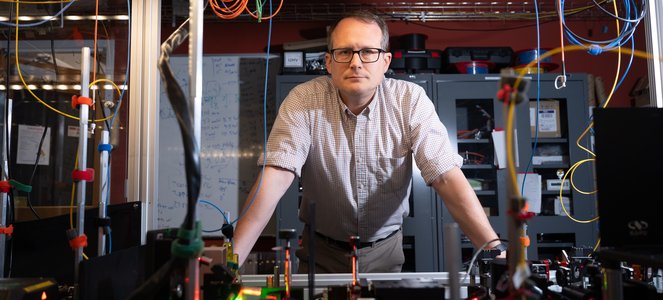 Image of Nick Hutzler leaning on lab equipment