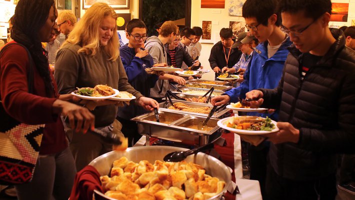 Postdocs and grad students line up to scoop traditional Thanksgiving dishes onto plates