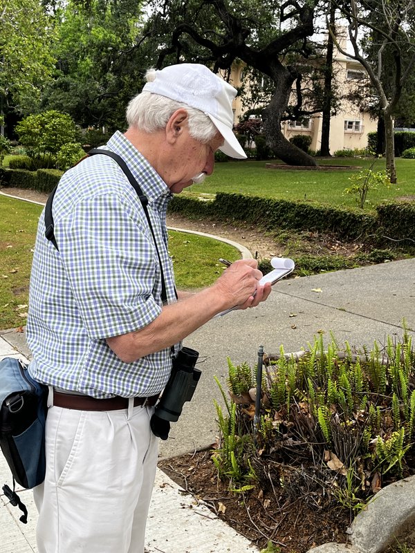 Alan Cummings marks his checklist while bird-watching on campus.
