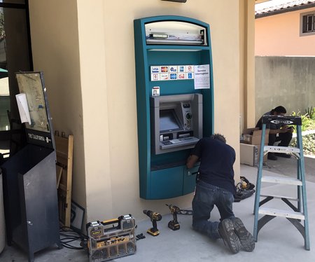A workman helps finish the installation of an ATM on the west side of Chandler.