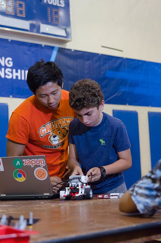 Child and mentor over robot