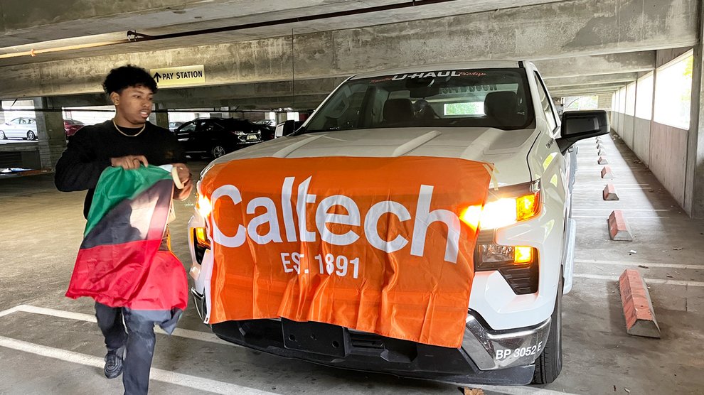 Jayden Nyamiaka carries a Pan-African flag to attach to the Caltech float.