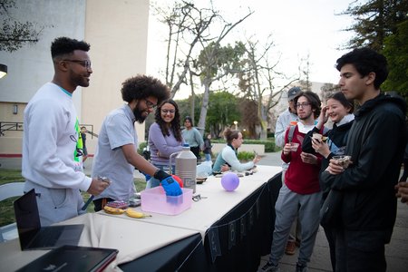 Graduate students demonstrate a science experiment involving liquid nitrogen.