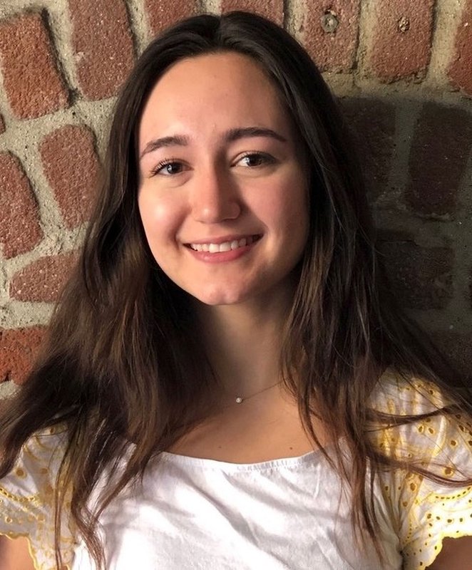 A woman with brown hair smiles for a photo