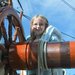A picture of Lily Dove as a child, next to the helm of a ship
